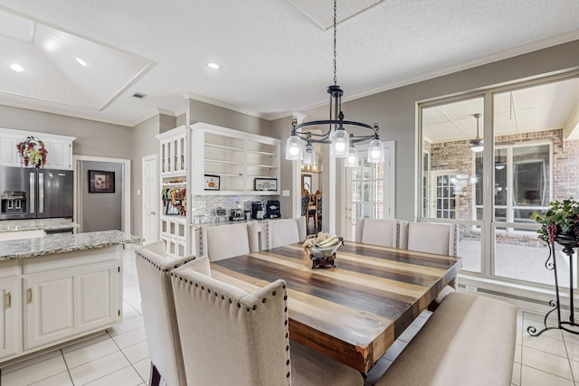 dining space with light tile patterned flooring, crown molding, an inviting chandelier, and a textured ceiling