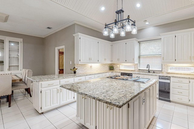 kitchen with sink, a center island, decorative backsplash, light tile patterned flooring, and decorative light fixtures