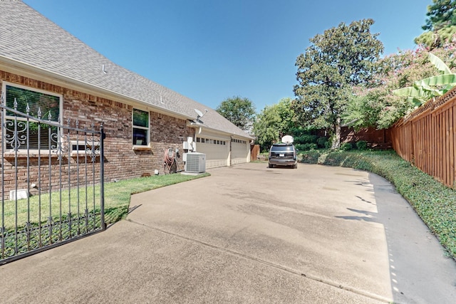 view of property exterior with a garage and cooling unit