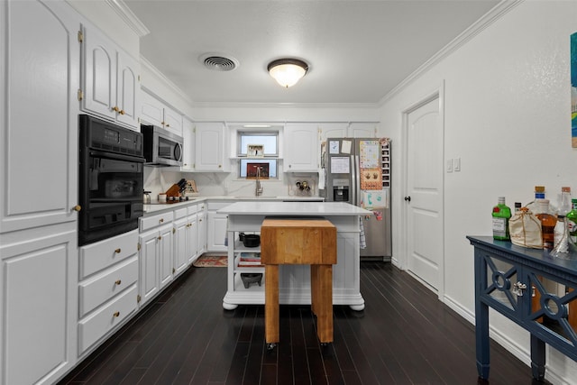 kitchen with a kitchen island, white cabinets, and black appliances