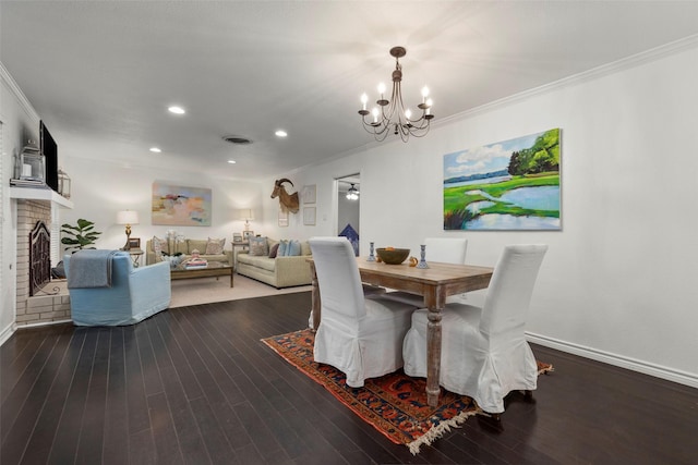 dining room featuring wood-type flooring, a brick fireplace, a chandelier, and crown molding