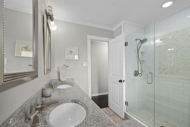 bathroom featuring a shower with door, ornamental molding, and vanity