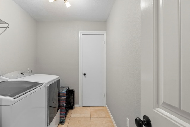 clothes washing area with light tile patterned flooring and independent washer and dryer