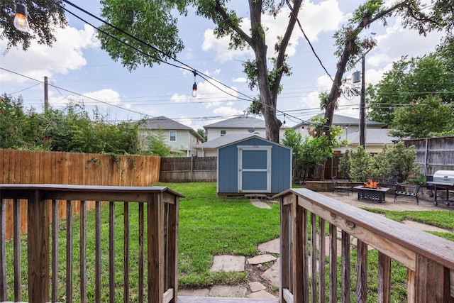 view of yard with a storage unit and an outdoor fire pit