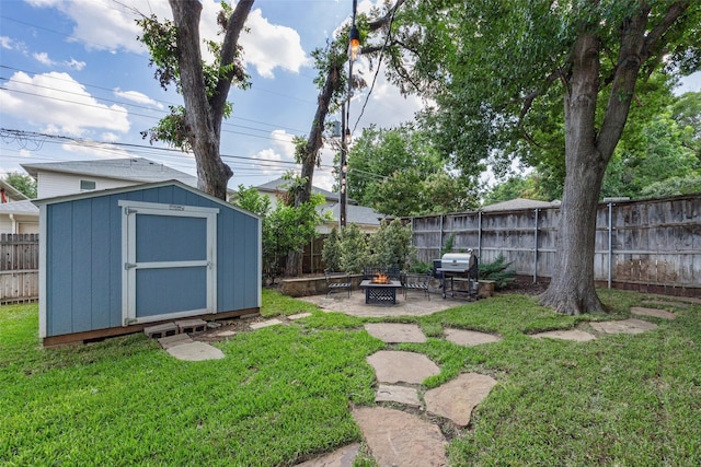 view of yard featuring a storage shed and a fire pit