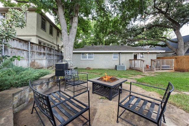 view of patio featuring a grill, cooling unit, and a fire pit