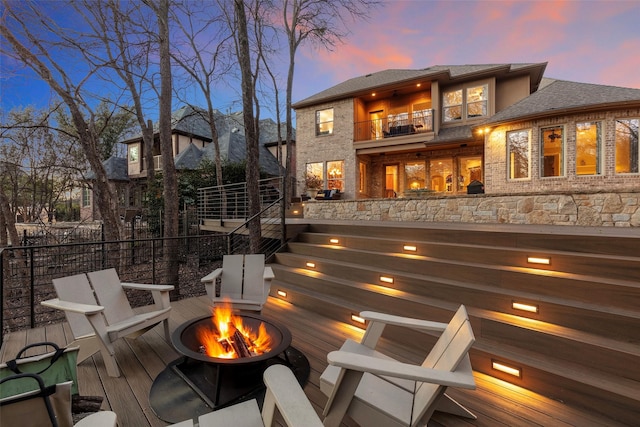 exterior space featuring a balcony and an outdoor fire pit