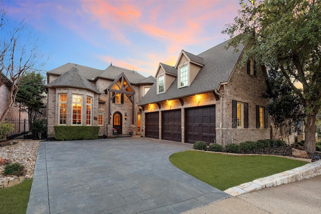 view of front of house with a garage and a lawn