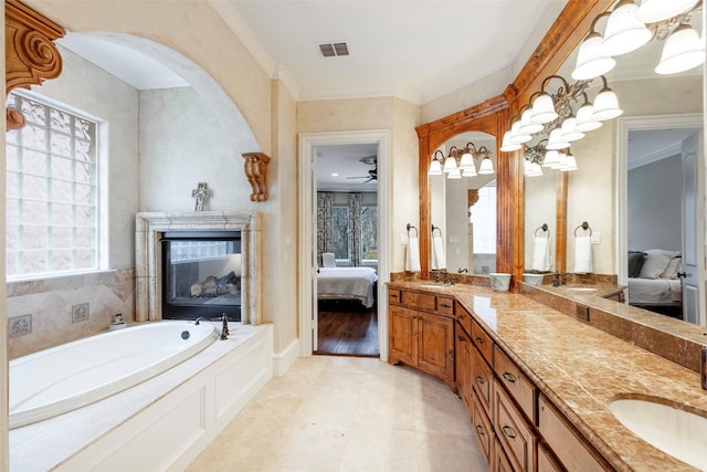 bathroom with a tub to relax in, ornamental molding, vanity, and tile patterned flooring