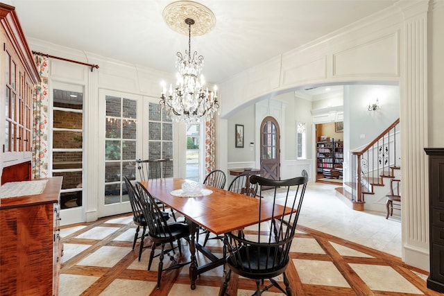 dining space featuring crown molding, a chandelier, and french doors