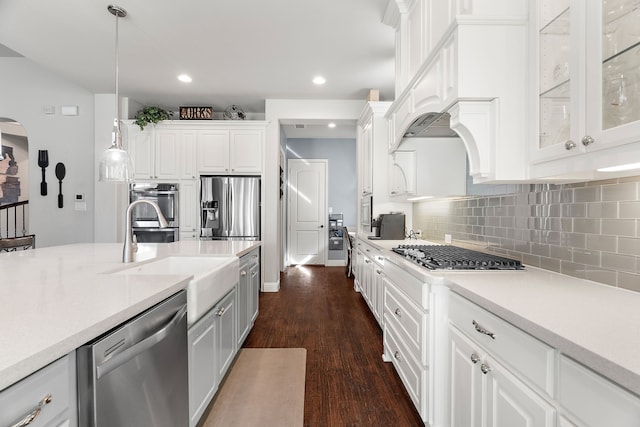 kitchen with sink, decorative light fixtures, stainless steel appliances, and white cabinets