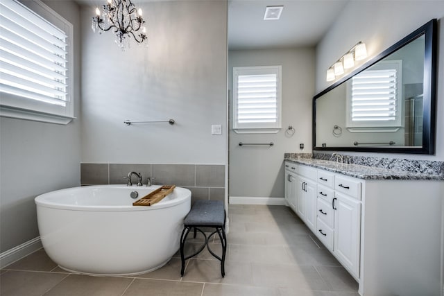 3316 Dovehill Dr, Northlake, TX 76247 - full bathroom with double vanity, a freestanding bath, a chandelier, baseboards, and tile patterned flooring