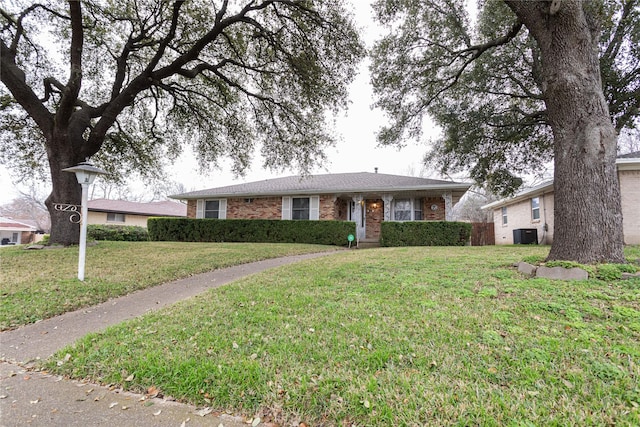 ranch-style home featuring a front yard and central air condition unit