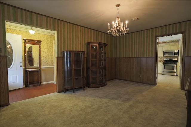 carpeted empty room with an inviting chandelier