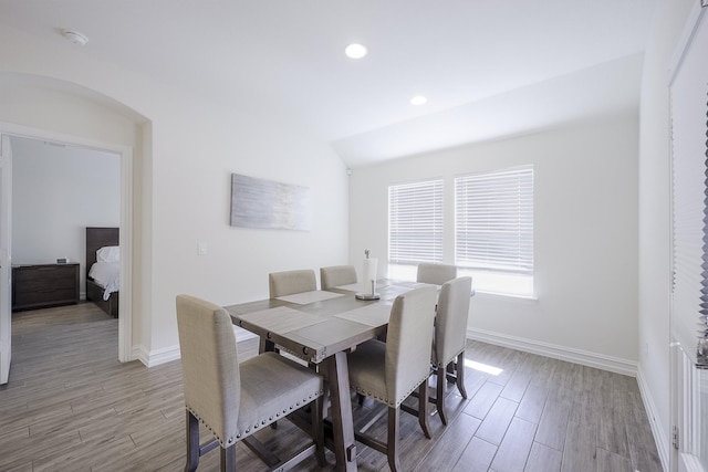 dining space featuring lofted ceiling and light hardwood / wood-style flooring