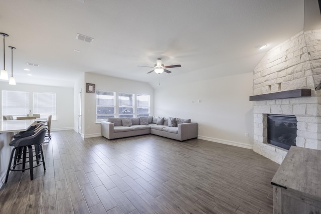 living room featuring ceiling fan, dark hardwood / wood-style floors, and a fireplace