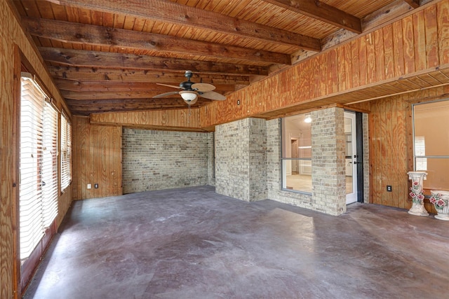 empty room with ceiling fan, wooden walls, wooden ceiling, and beam ceiling