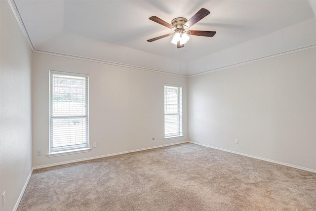 spare room featuring ceiling fan, light colored carpet, and a tray ceiling