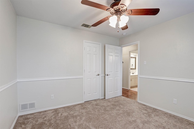 unfurnished bedroom featuring light carpet, ceiling fan, and a closet