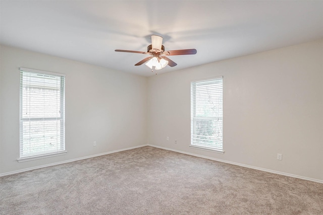 carpeted spare room featuring ceiling fan