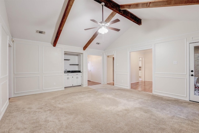 unfurnished living room with lofted ceiling with beams, light colored carpet, and ceiling fan