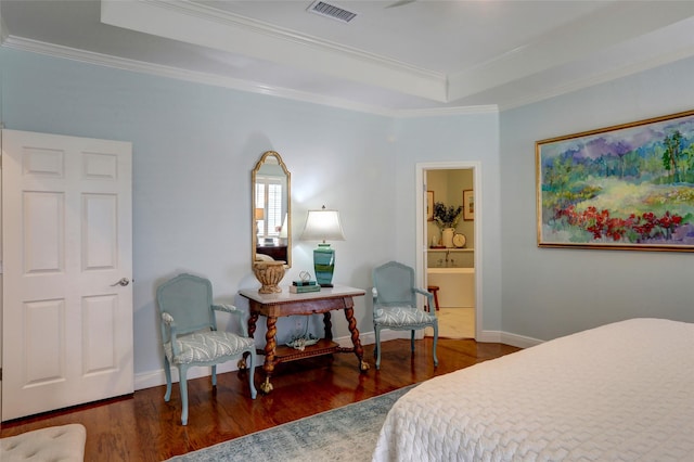 bedroom with dark hardwood / wood-style flooring, a tray ceiling, ensuite bath, and ornamental molding