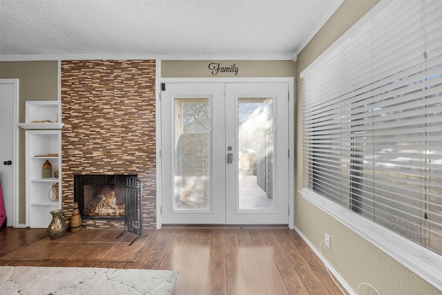 doorway to outside featuring hardwood / wood-style floors, crown molding, and a textured ceiling