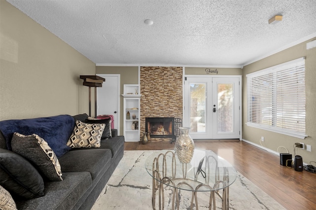 living room featuring wood-type flooring, french doors, a textured ceiling, and plenty of natural light