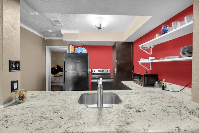 kitchen with sink, stainless steel electric range oven, a textured ceiling, and black fridge