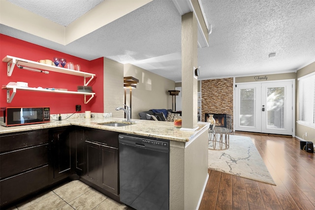 kitchen with dishwasher, sink, kitchen peninsula, light stone countertops, and light wood-type flooring