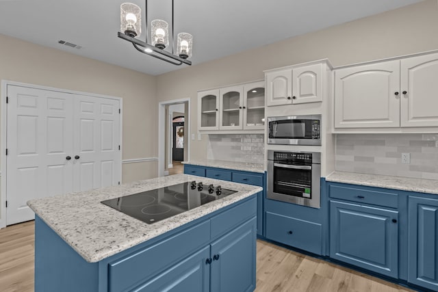 kitchen with blue cabinetry, appliances with stainless steel finishes, white cabinetry, hanging light fixtures, and a center island