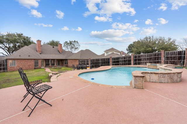 view of swimming pool with an in ground hot tub, a yard, and a patio area