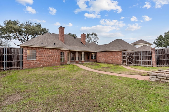 rear view of property with a lawn