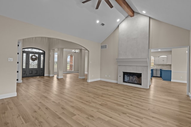 unfurnished living room with high vaulted ceiling, light wood-type flooring, ceiling fan with notable chandelier, and beam ceiling