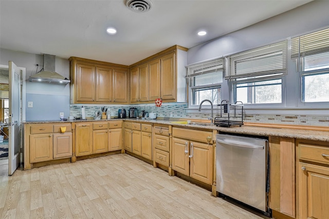 kitchen featuring wall chimney exhaust hood, sink, tasteful backsplash, light hardwood / wood-style flooring, and dishwasher