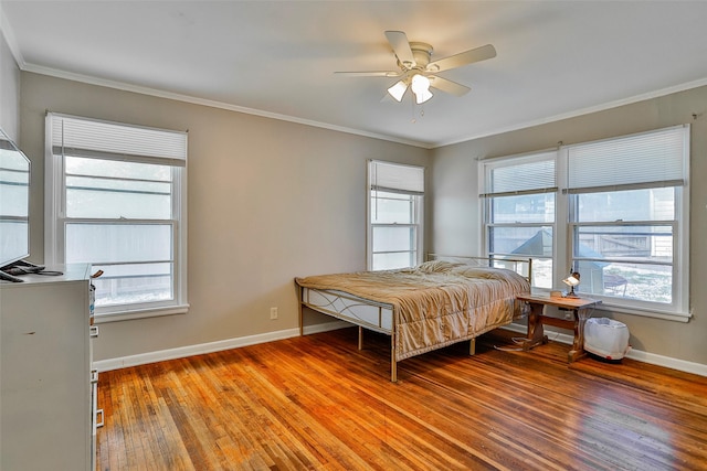 bedroom with crown molding, multiple windows, and hardwood / wood-style flooring