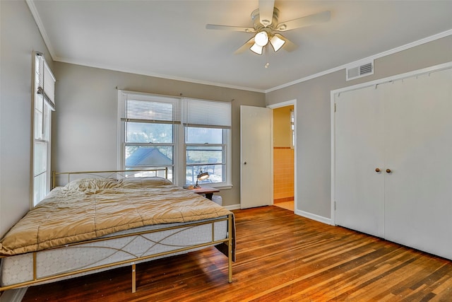 bedroom with hardwood / wood-style floors, ornamental molding, a closet, and ceiling fan