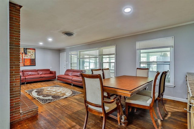 dining space with crown molding and dark wood-type flooring