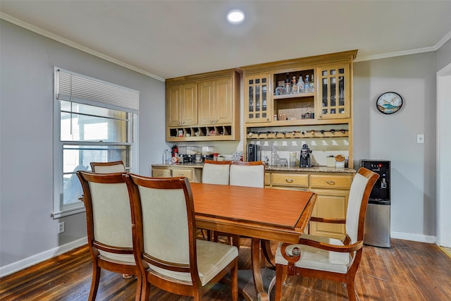 dining area with crown molding, dark wood-type flooring, and bar area