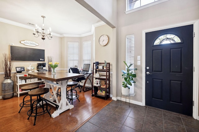 foyer entrance featuring dark hardwood / wood-style flooring, a notable chandelier, and ornamental molding