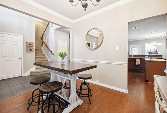 dining space featuring crown molding, dark hardwood / wood-style flooring, and a chandelier