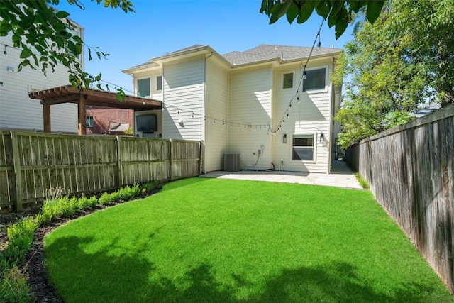 rear view of property with central AC, a yard, a pergola, and a patio