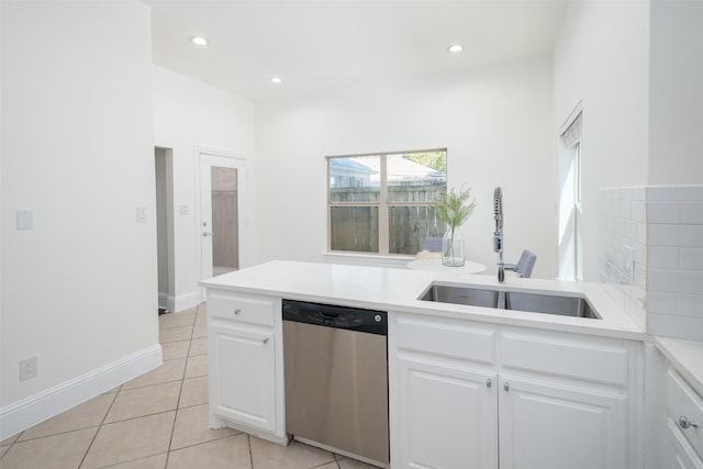 kitchen featuring stainless steel dishwasher, light tile patterned floors, sink, and white cabinets