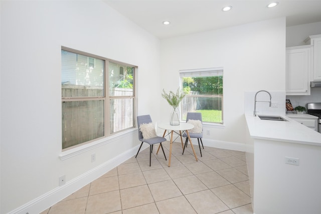 dining space featuring sink and light tile patterned floors