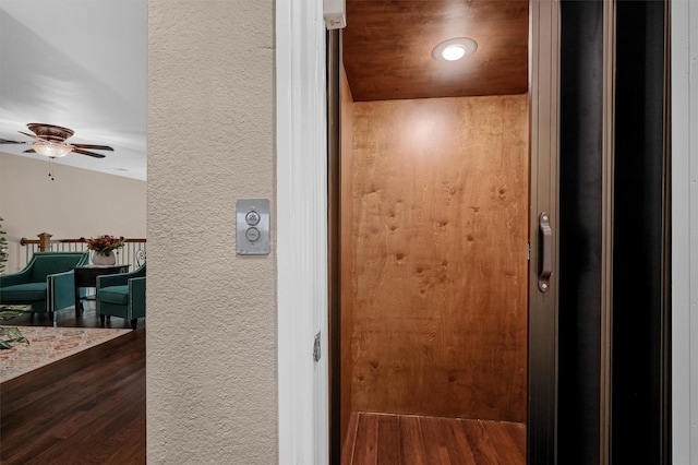 interior details featuring wood-type flooring, elevator, and ceiling fan
