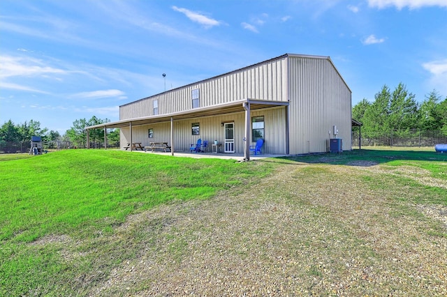 rear view of house with a patio area, central AC unit, and a lawn