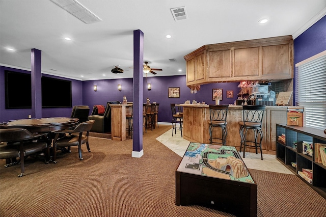 interior space featuring ornamental molding, ceiling fan, and bar area