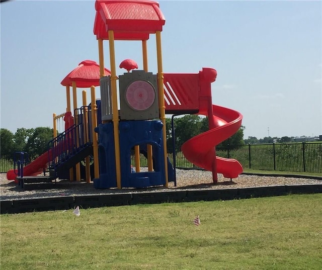 community play area featuring fence and a lawn