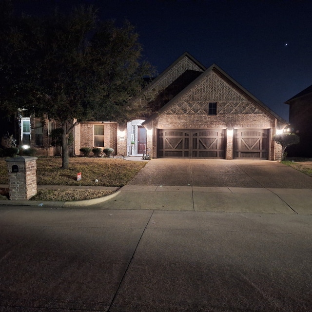 view of front of house featuring a garage, brick siding, and driveway