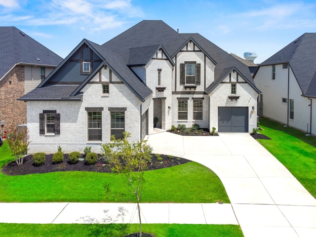 view of front of property featuring driveway, a garage, a shingled roof, a front yard, and brick siding